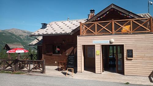 un bâtiment avec une enseigne devant lui dans l'établissement Yourte de montagne, à Colmars