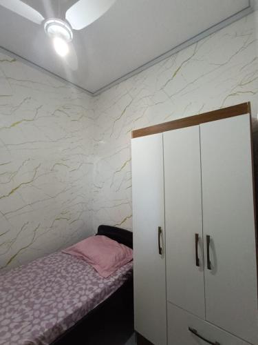 1 dormitorio con 1 cama y armario blanco en Quarto em Apartamento no Centro en Campo Grande