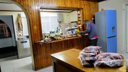 un hombre parado en un mostrador en una cocina en Vimbainashe Villas 