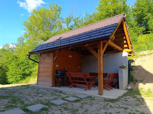 einen Holzpavillon mit einem Tisch und Stühlen in der Unterkunft Horná chata u Bratrikov in Haligovce