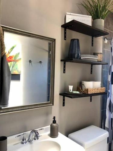 a bathroom with a mirror and a sink and a toilet at Stay with Class in the heart of wine country in San Antonio de las Minas