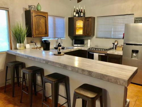 a kitchen with a large counter with bar stools at Stay with Class in the heart of wine country in San Antonio de las Minas