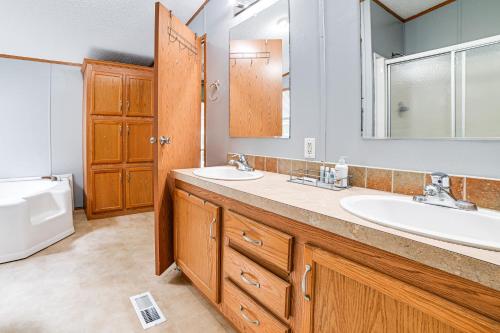 a bathroom with two sinks and a mirror at Kuttawa Vacation Rental with Smart TV, Near Marinas! in Kuttawa