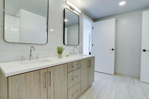 a bathroom with two sinks and a mirror at Experience Comfort and Style at Clarendon in Arlington