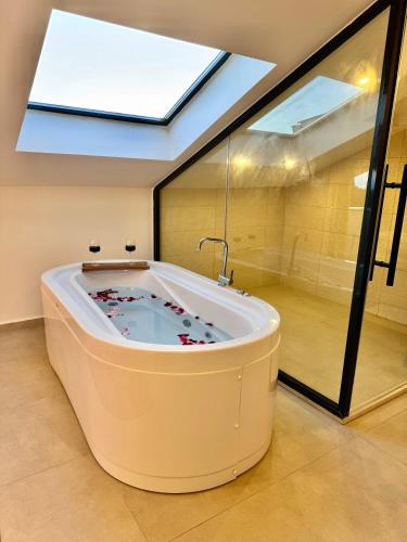 a large bath tub in a room with a skylight at Villa İon İndoor heated pool, Sauna, Jacuzzi, Underfloor heating system in Fethiye