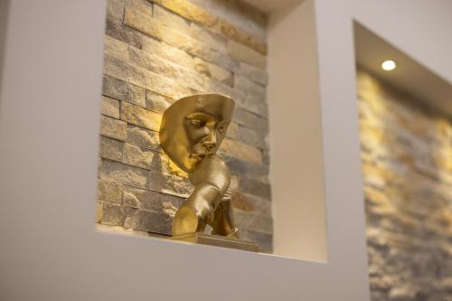 a bronze statue of a woman sitting on a ledge at Javorov list LUX in Šabac