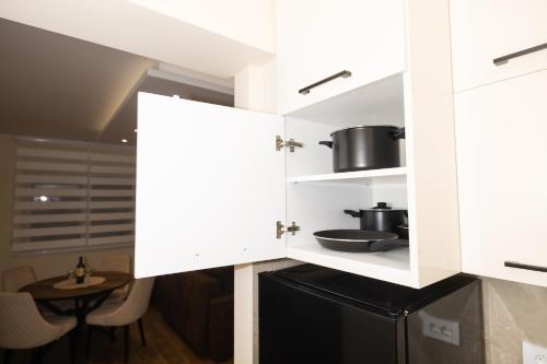 a kitchen with white cabinets and a table at Javorov list LUX in Šabac