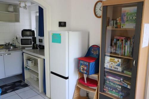 a kitchen with a white refrigerator and a book shelf at Bungalow, Teupitz in Teupitz