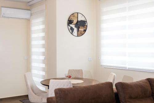 a dining room with a table and chairs and a clock at Javorov list LUX in Šabac