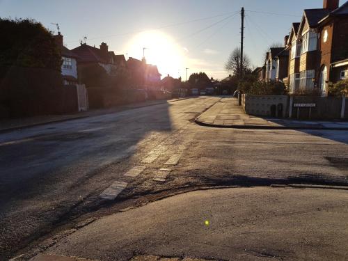 Une rue vide avec le soleil au loin dans l'établissement Fairhaven Guest Accommodation, à Nottingham