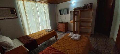 a small room with two beds and a dresser at Nuevo Residencial Uno in Puerto Iguazú