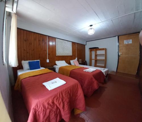 a hotel room with two beds and a ladder at Nuevo Residencial Uno in Puerto Iguazú