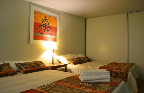 Habitación de hotel con 2 camas y mesa con lámpara en Centro Apart en Villa Elisa