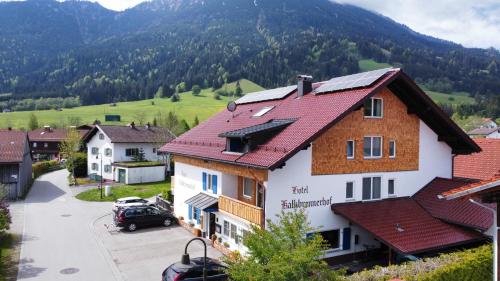 a village in the mountains with a car parked in the driveway at Hotel-Garni Kalkbrennerhof in Pfronten