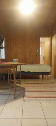 um quarto com uma cama e uma mesa no chão em Hostal Acuariano Piscoelqui em Pisco Elqui
