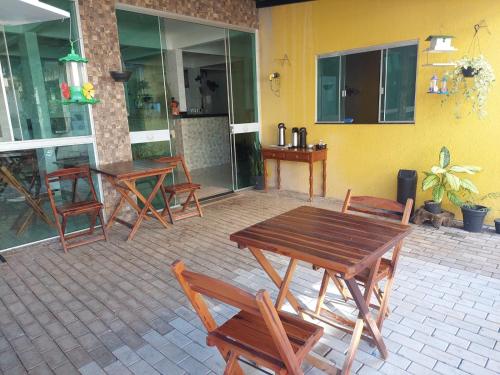a patio with wooden tables and chairs in front of a building at Quarto Solteiros Amigos - Queen's Hotel in Formosa