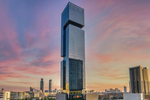 een weergave van een hoge wolkenkrabber in een stad bij The First Collection at Jumeirah Village Circle, a Tribute Portfolio Hotel in Dubai