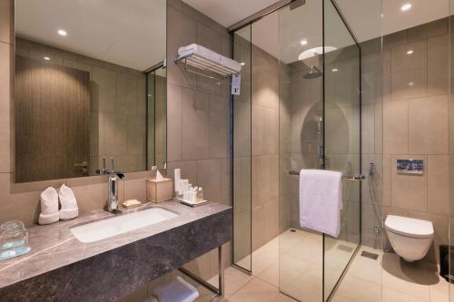 杜拜的住宿－The First Collection at Jumeirah Village Circle, a Tribute Portfolio Hotel，一间带水槽和淋浴的浴室