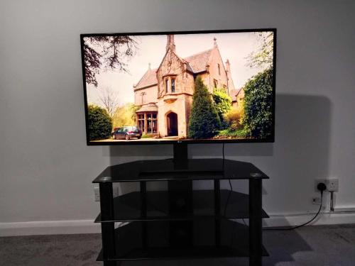 a flat screen tv sitting on top of a table at Monmouth House Aylesbury Premier Quality Accommodation For Larger Families Contractors And Professionals Sleeps Up to 6 Guests in Buckinghamshire