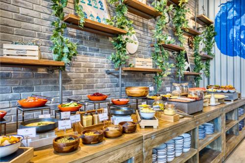 a buffet line with various food items on display at The First Collection Dubai Jumeirah Village Circle, a Tribute Portfolio Hotel in Dubai