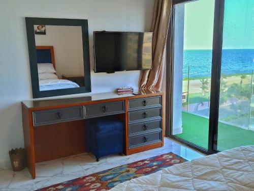 a bedroom with a tv and a dresser with a mirror at Porto Said شاليه ملكى صف اول بحر بورتو سعيد in Port Said