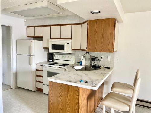 a kitchen with a white refrigerator and a sink at Dells Suite Dreams At Lighthouse Cove Condominiums in Wisconsin Dells