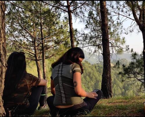 two girls sitting on a hill looking at the forest at Lacasa Luxury Stays in Shogi