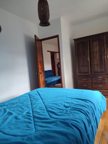 キトにあるPintagMagicHouseのベッドルーム(青いベッド1台、鏡付)
