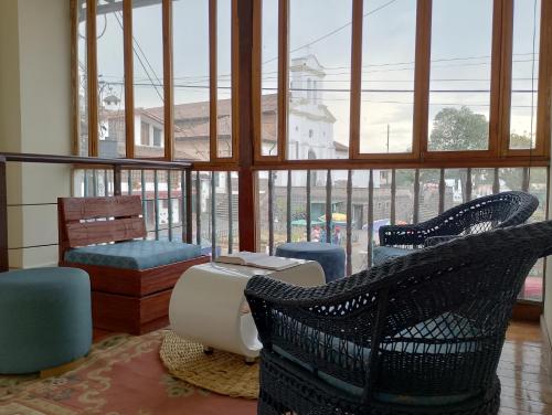 un soggiorno con sedie e una grande finestra di PintagMagicHouse a Quito