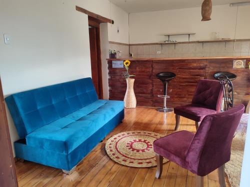 un divano blu e due sedie in soggiorno di PintagMagicHouse a Quito