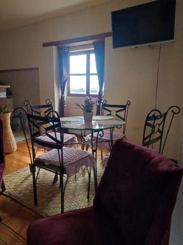 un soggiorno con tavolo, sedie e TV di PintagMagicHouse a Quito