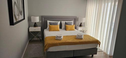 a bedroom with a large bed with yellow pillows at Faro Main Avenue Apartment II in Faro