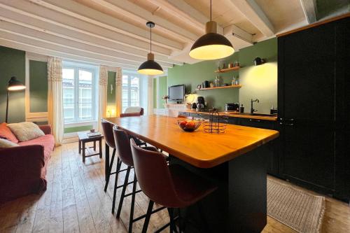 une cuisine avec une grande table et des chaises en bois dans l'établissement Appart de charme, 2 chambres en centre ville, à Cherbourg en Cotentin