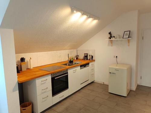 a kitchen with white cabinets and a counter top at RuhrHeimat Ferienwohnung am Ruhrtalradweg in Arnsberg in Arnsberg