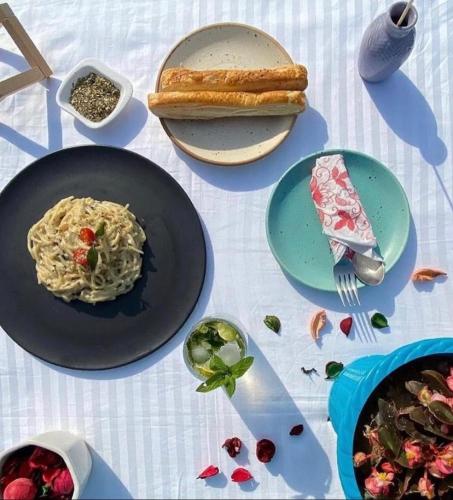 a table with plates of food and a plate of pasta at Lacasa Luxury Stays in Shogi