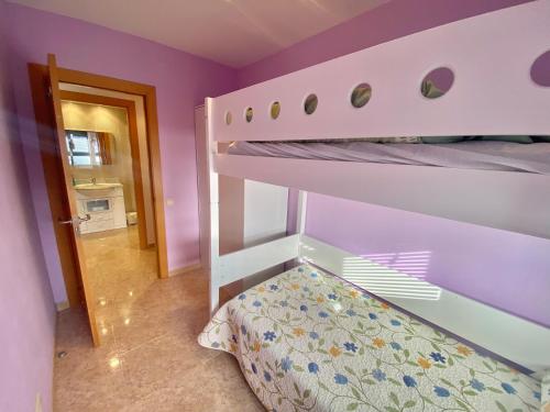 a bunk bed in a room with purple walls at Apartamento Cinca Pirineo en Aínsa in Aínsa