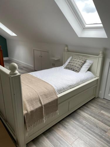 a bedroom with a white bed with a skylight at Seán Ógs House in Gortatlea