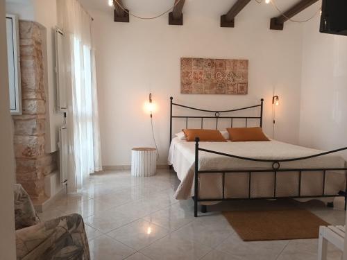 a bedroom with a bed with orange pillows on it at Antiche Mura Apartments"Cielo di Puglia" -2 matrimoniali, cucina,letto singolo e terrazzo in Turi