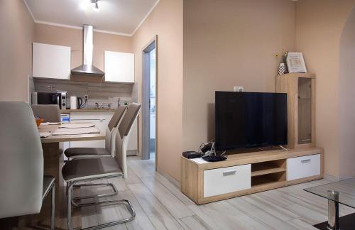 a kitchen with a dining table and a television on a cabinet at Rooms & Apartments Banjac in Maribor
