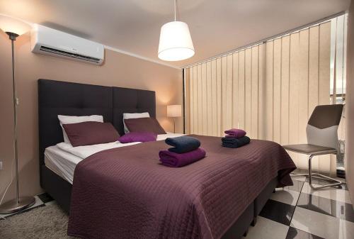 a bedroom with a large bed with purple pillows on it at Rooms & Apartments Banjac in Maribor
