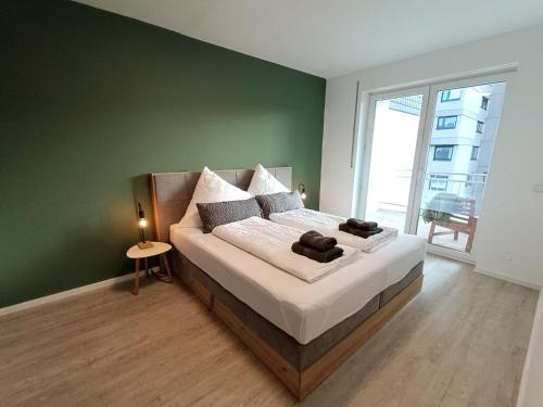 a bedroom with a large bed with a green wall at RuhrHeimat Ferienwohnung am Ruhrtalradweg in Arnsberg in Arnsberg