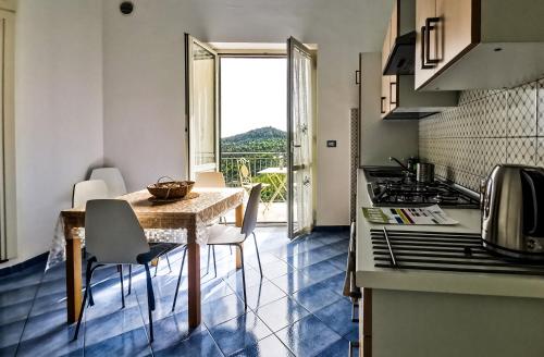a kitchen with a table with chairs and a view at Cristina Home in Vietri