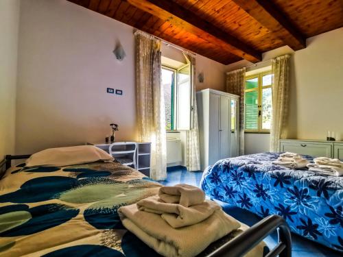 a bedroom with two beds and two windows at Cristina Home in Vietri