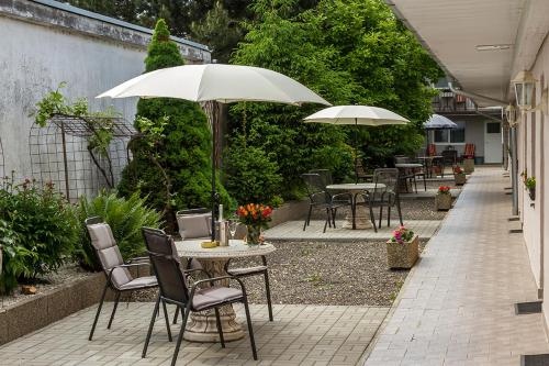 an outdoor patio with tables and chairs and umbrellas at Apartmany Tereza & free parking in Bratislava