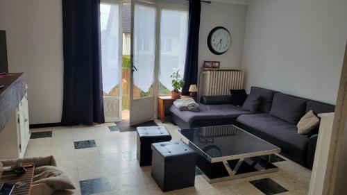 a living room with a couch and a table at Maison 24h du Mans in Arnage