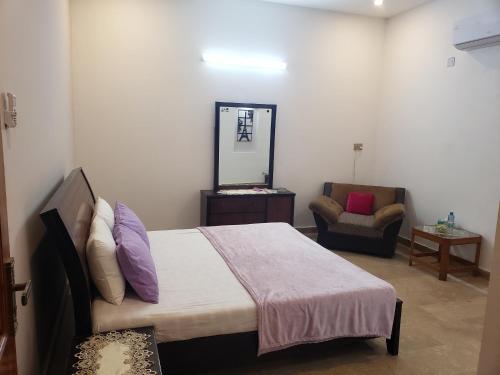una camera con letto, specchio e sedia di lalic lavender a Islamabad