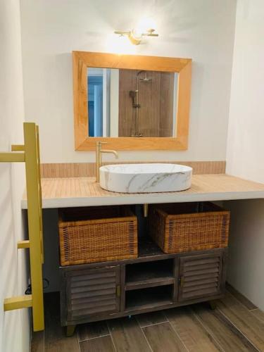 La salle de bains est pourvue d'un lavabo avec miroir et de paniers. dans l'établissement Duplex pour 2 à 6 personnes avec terrasse en plein cœur de la citadelle de Bonifacio, à Bonifacio
