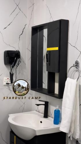 a bathroom with a white sink and a mirror at RUM STARDUST lUXURY CAMP in Wadi Rum