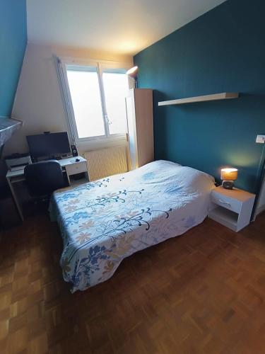 une chambre avec un lit, un bureau et une fenêtre dans l'établissement Appartement atypique de 70 m2, à Aubervilliers
