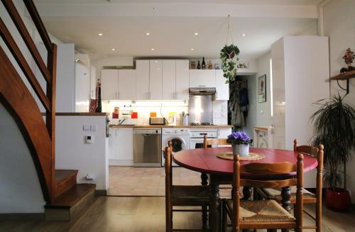 une cuisine et une salle à manger avec une table et des chaises dans l'établissement Appartement atypique de 70 m2, à Aubervilliers